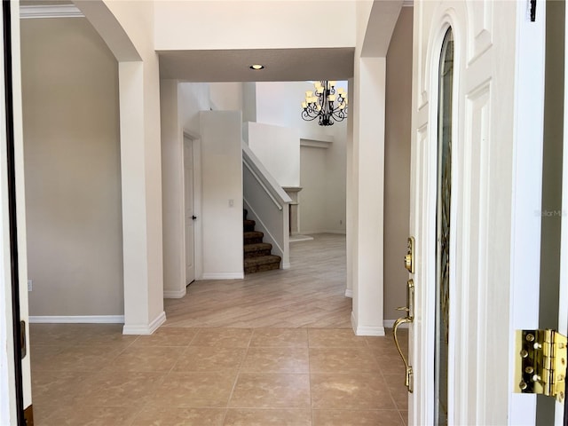 hallway with an inviting chandelier and light tile patterned flooring