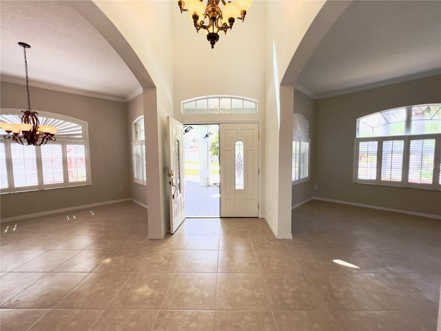 foyer entrance with tile patterned floors, an inviting chandelier, and a wealth of natural light