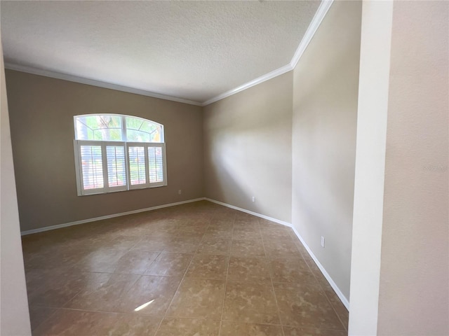 empty room featuring dark tile patterned flooring, a textured ceiling, and crown molding