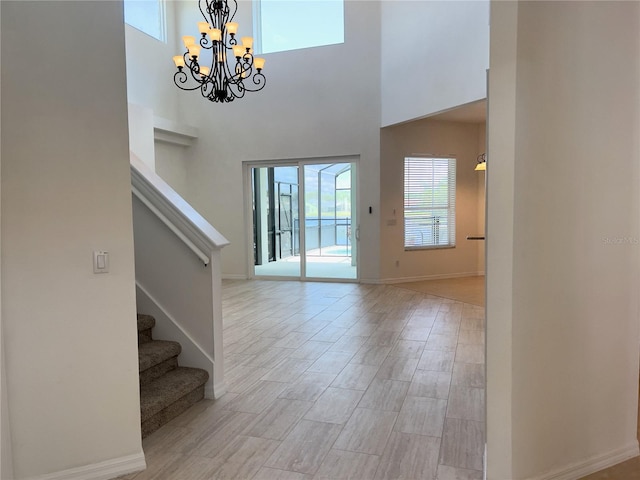 foyer entrance featuring a towering ceiling and a chandelier