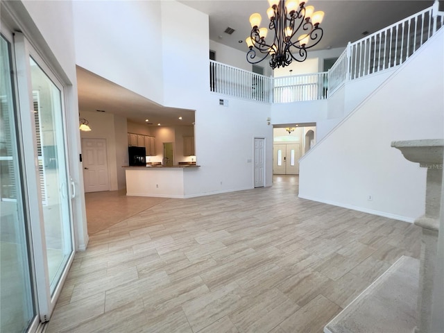 living room with a towering ceiling and a chandelier