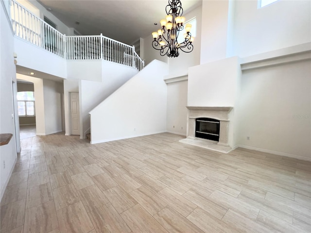 unfurnished living room with a high ceiling and a chandelier