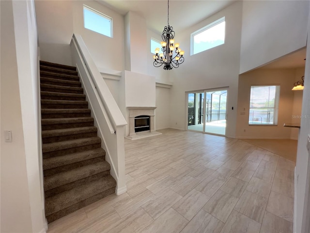 unfurnished living room featuring a high ceiling and a notable chandelier