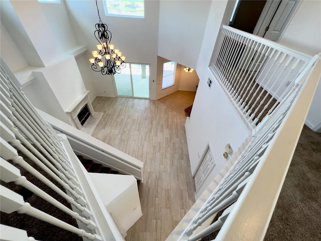 foyer with a towering ceiling, an inviting chandelier, and light hardwood / wood-style flooring