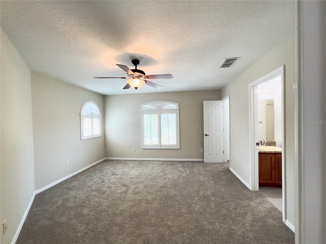 carpeted spare room featuring sink, a textured ceiling, and ceiling fan