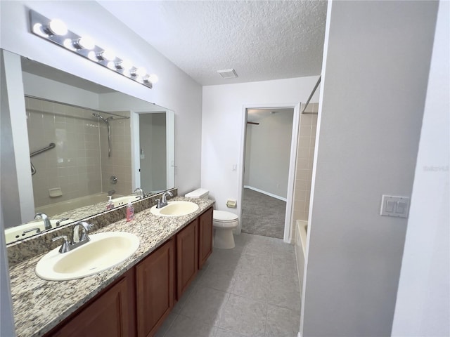 full bathroom with toilet, tiled shower / bath combo, a textured ceiling, and vanity