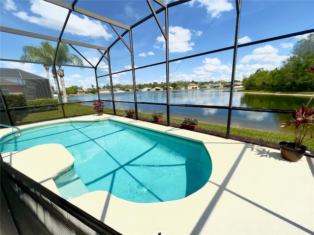 view of swimming pool featuring a patio, glass enclosure, and a water view