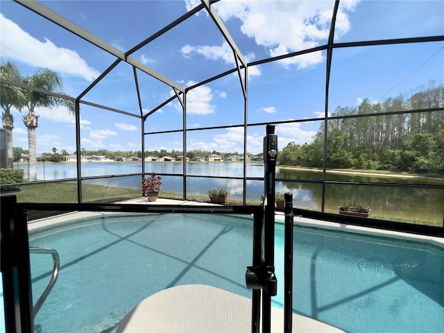 view of pool with glass enclosure and a water view