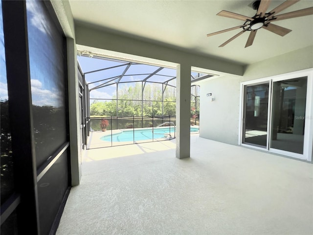 unfurnished sunroom featuring ceiling fan and a swimming pool