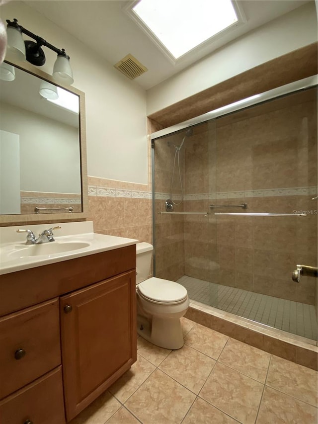 bathroom featuring an enclosed shower, tile patterned flooring, vanity, tile walls, and toilet