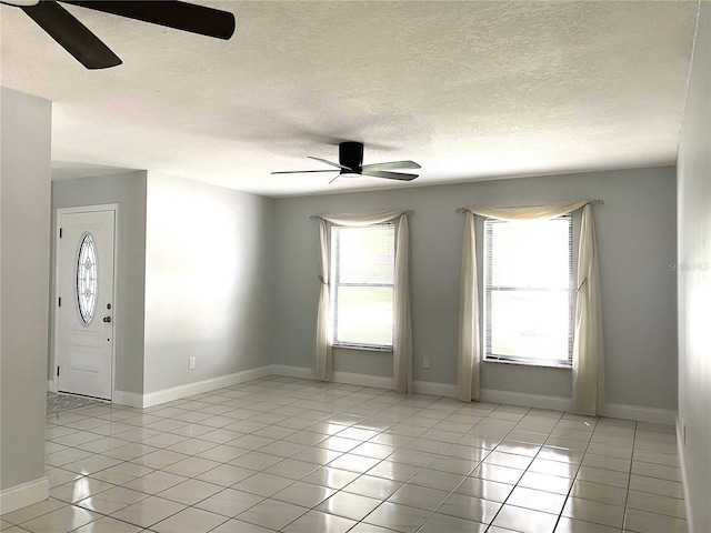 tiled empty room featuring ceiling fan, plenty of natural light, and a textured ceiling