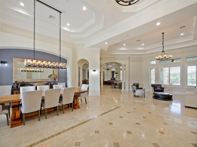 dining room with a raised ceiling and ornamental molding