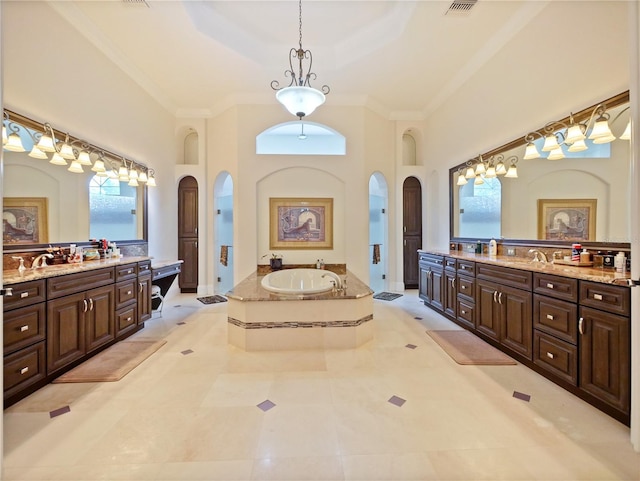 bathroom featuring vanity, a high ceiling, tile patterned flooring, ornamental molding, and tiled tub