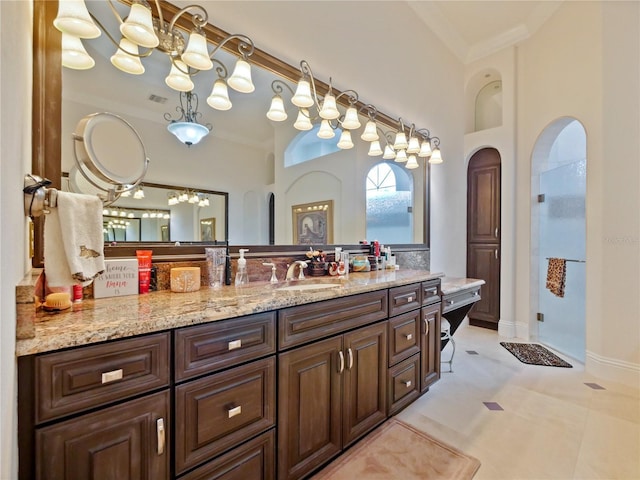 bathroom with tile patterned flooring, a towering ceiling, vanity, and ornamental molding