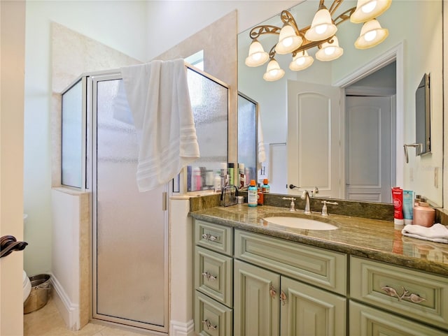 bathroom with tile patterned flooring, vanity, a shower with shower door, and an inviting chandelier