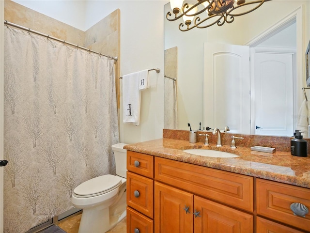 bathroom with vanity, toilet, and an inviting chandelier