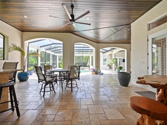 sunroom featuring ceiling fan and wood ceiling