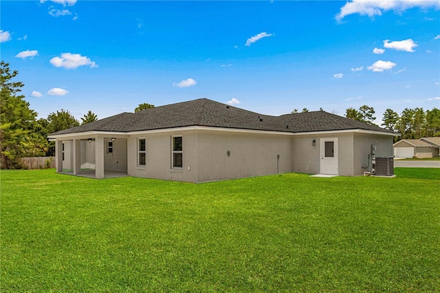 back of house featuring a lawn and central air condition unit