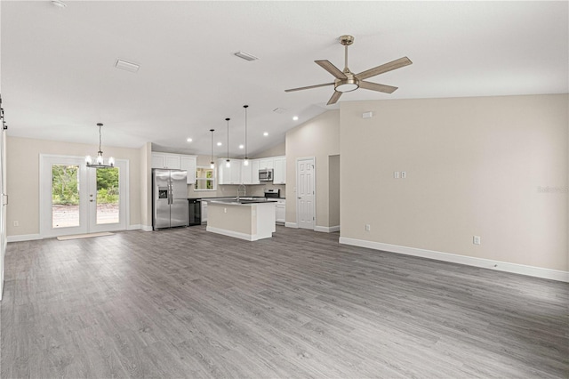 unfurnished living room featuring lofted ceiling, hardwood / wood-style flooring, sink, and ceiling fan