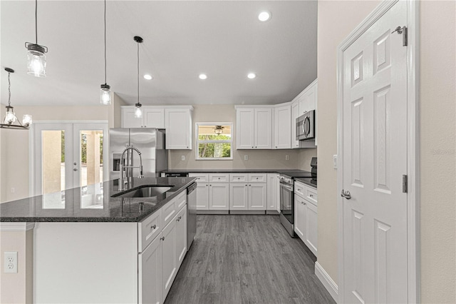 kitchen with hanging light fixtures, sink, white cabinetry, an island with sink, and stainless steel appliances