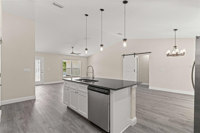 kitchen with white cabinetry, sink, stainless steel dishwasher, a center island with sink, and a barn door