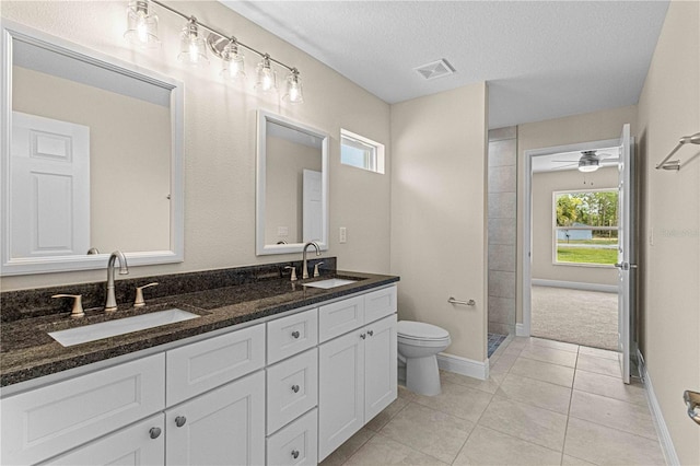 bathroom featuring plenty of natural light, a textured ceiling, tile patterned flooring, and vanity