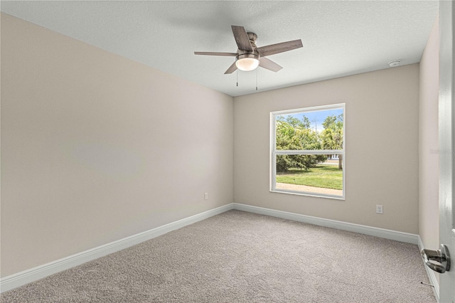 empty room featuring ceiling fan and carpet