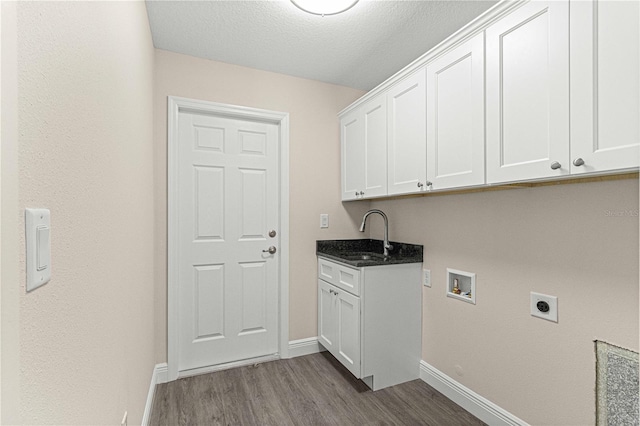 laundry room featuring washer hookup, hardwood / wood-style flooring, sink, hookup for an electric dryer, and cabinets