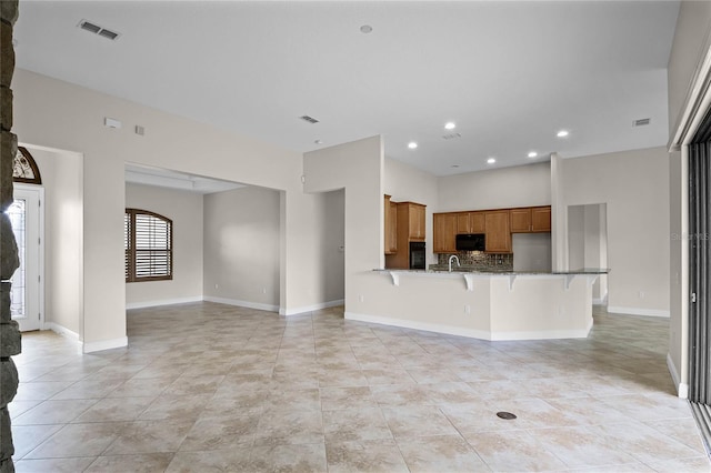 unfurnished living room with light tile patterned flooring and sink