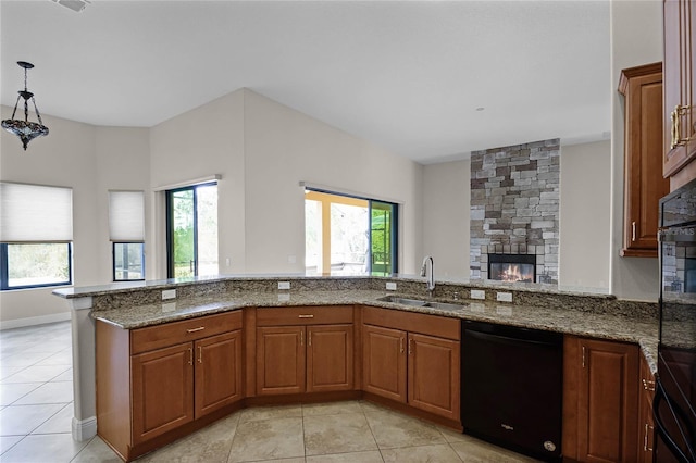 kitchen with sink, stone countertops, light tile patterned floors, dishwasher, and kitchen peninsula