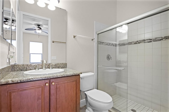 bathroom with ceiling fan, vanity, toilet, and a shower with shower door