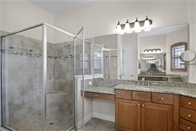 bathroom featuring vanity, a shower with shower door, and tile patterned floors