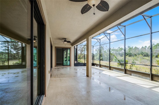 unfurnished sunroom with ceiling fan