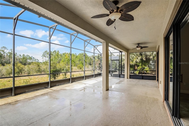 unfurnished sunroom featuring ceiling fan and a wealth of natural light