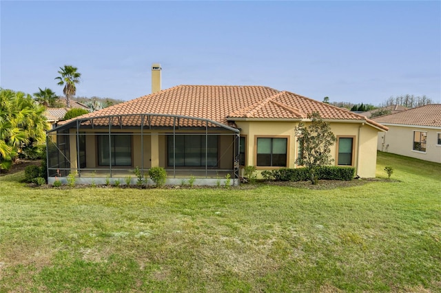 rear view of house with a yard and glass enclosure