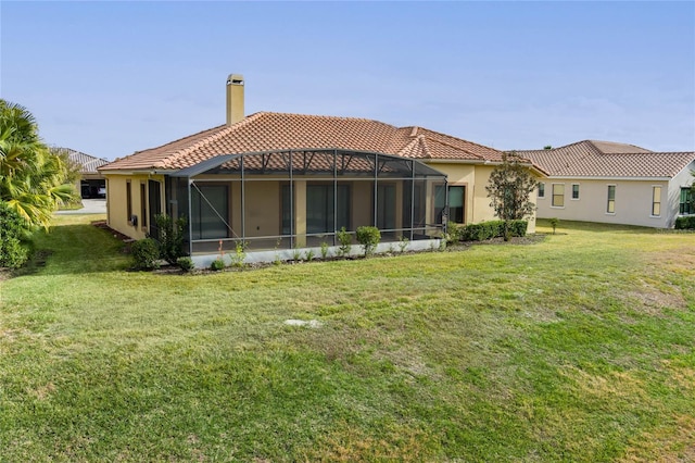 back of house with a lanai and a lawn