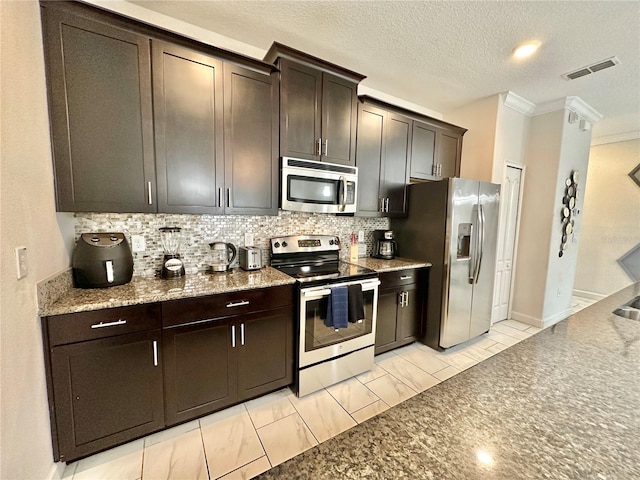 kitchen with stainless steel appliances, dark brown cabinetry, decorative backsplash, light tile patterned flooring, and ornamental molding