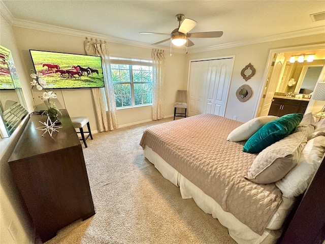 bedroom featuring carpet flooring, ceiling fan, ensuite bathroom, a closet, and ornamental molding