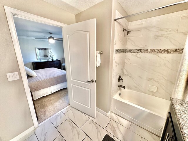 bathroom with a textured ceiling, tiled shower / bath combo, vanity, ceiling fan, and tile patterned floors