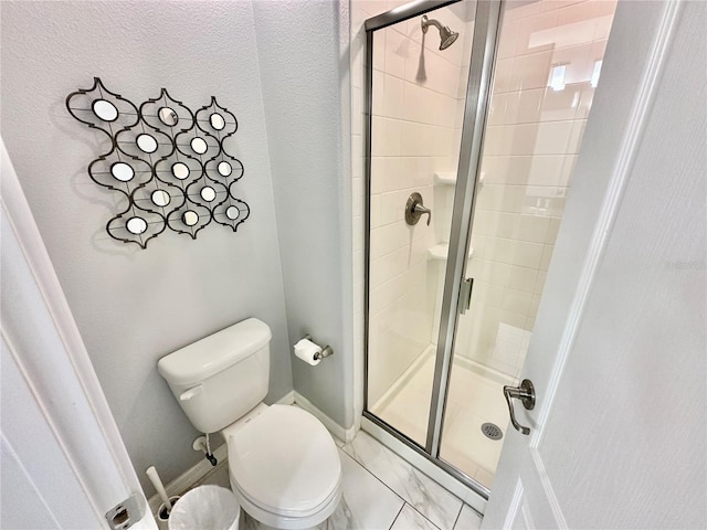 bathroom featuring a shower with shower door, toilet, and tile patterned floors