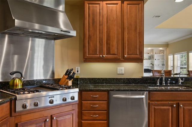 kitchen with stainless steel appliances, sink, extractor fan, and dark stone counters