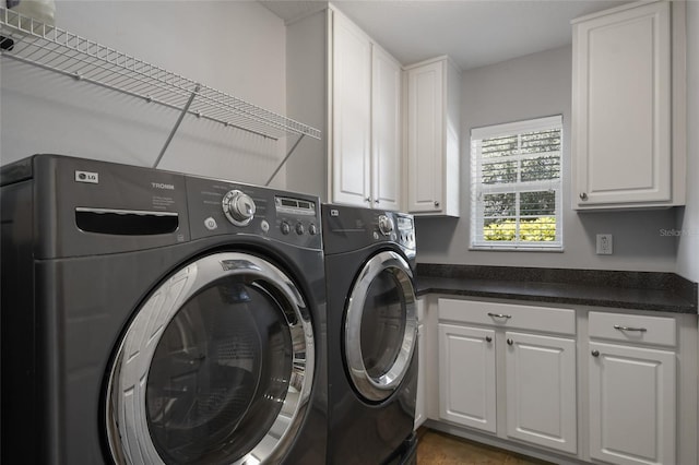 laundry area with washer and clothes dryer and cabinets