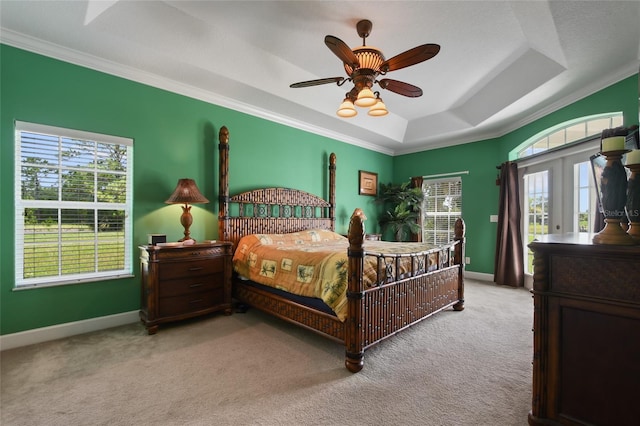 carpeted bedroom featuring a raised ceiling, crown molding, ceiling fan, and french doors