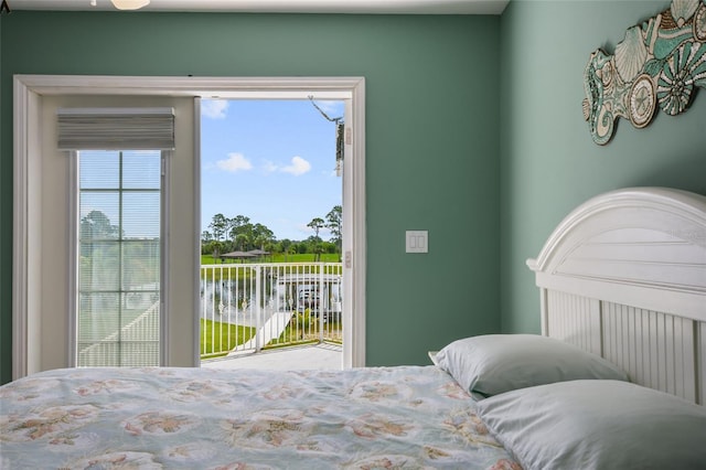 bedroom featuring a water view and access to outside