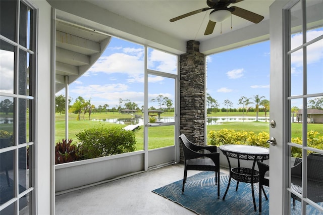 sunroom with a water view and ceiling fan