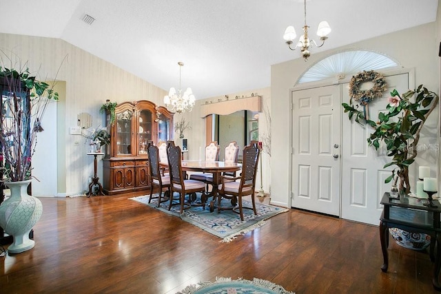 dining space with an inviting chandelier, lofted ceiling, and dark wood-type flooring