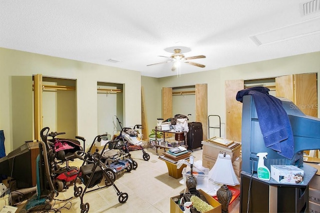 interior space featuring light tile patterned flooring, ceiling fan, and a textured ceiling