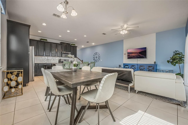 dining area with ceiling fan with notable chandelier and light tile patterned floors