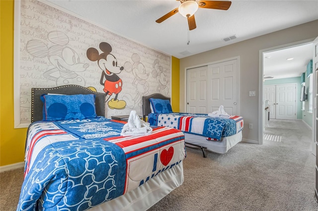 carpeted bedroom featuring a textured ceiling, ceiling fan, and a closet