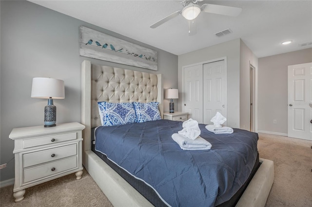 bedroom with ceiling fan, a closet, and light colored carpet